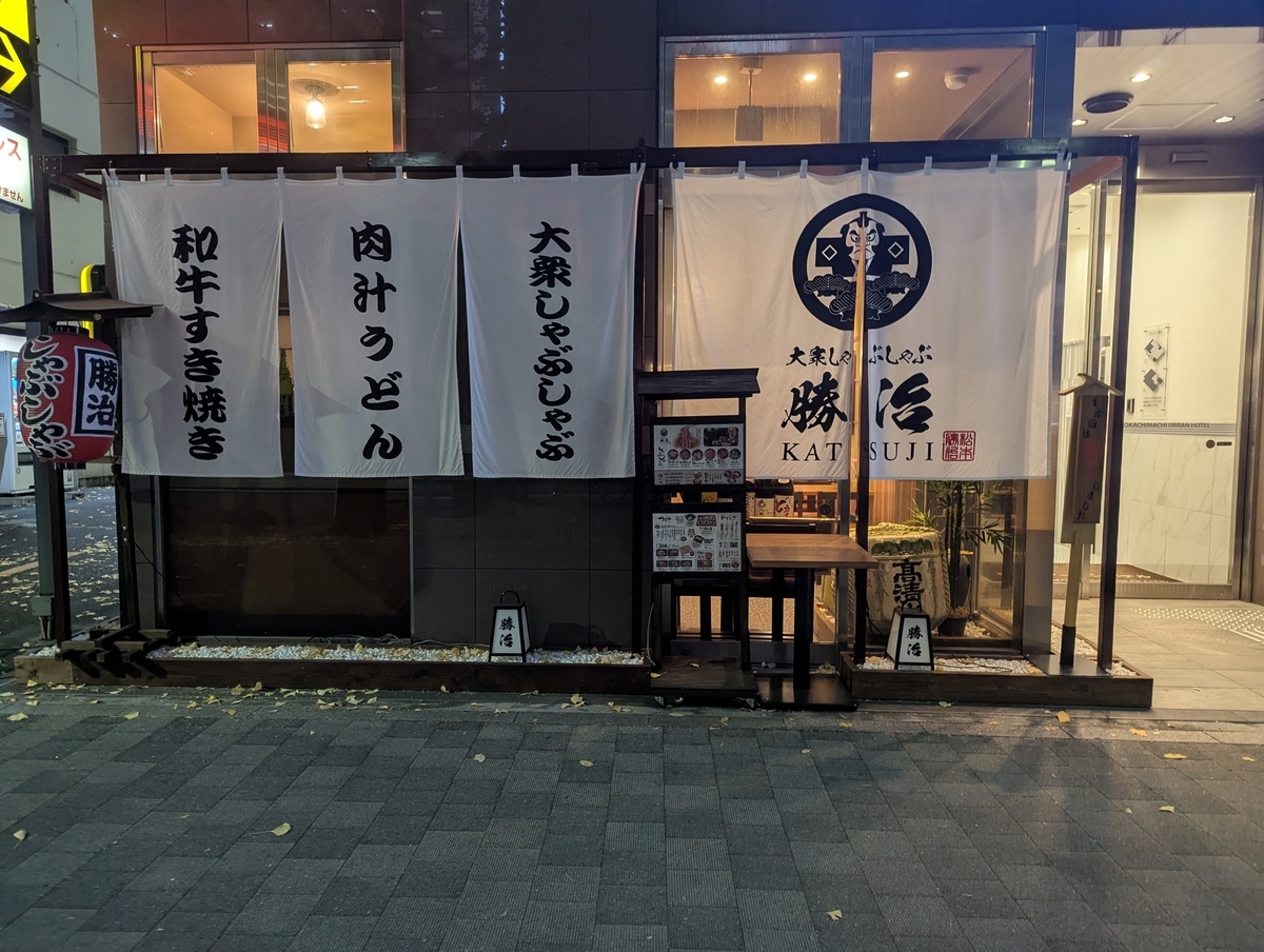 大衆しゃぶしゃぶ勝治 上野御徒町店の外観。白い暖簾に和牛すき焼き・肉汁うどん・大衆しゃぶしゃぶの文字が掲げられている