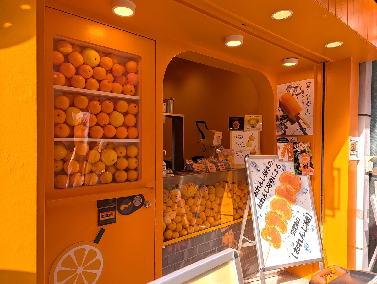 浅草オレンジ通りにある生搾りオレンジ専門店「浅草生搾り果汁おれんじーる」の外観。店内に並ぶ大量のオレンジが目を引く。