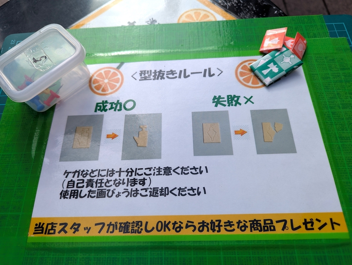 浅草生搾り果汁おれんじーるの「かたぬき」挑戦ルール。成功例と失敗例が分かる説明シートと道具。
