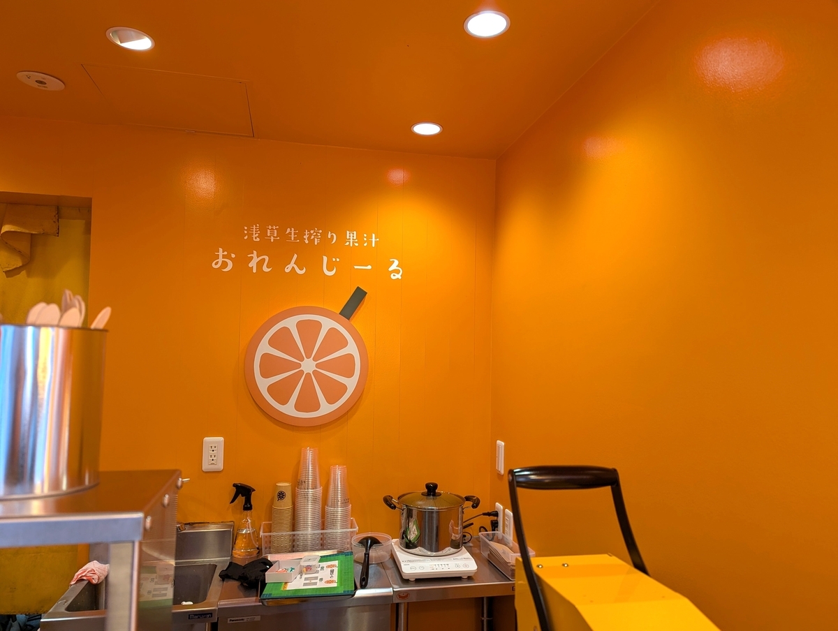 浅草生搾り果汁おれんじーるの店内カウンターとオレンジ色で統一された内装。生搾りジュースを提供する作業スペース。