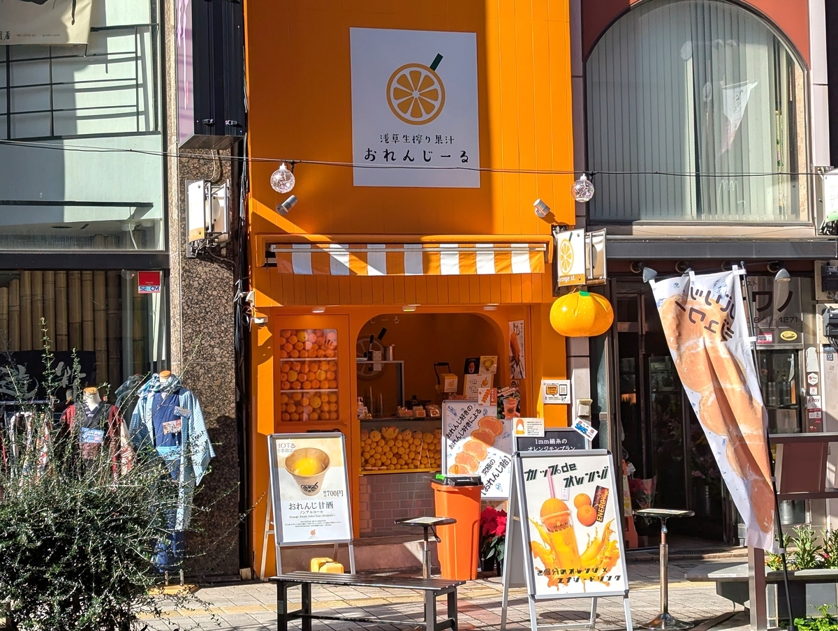 浅草生搾り果汁おれんじーるの外観。オレンジ色で統一された店舗と看板、浅草オレンジ通り沿いの立地が分かる。