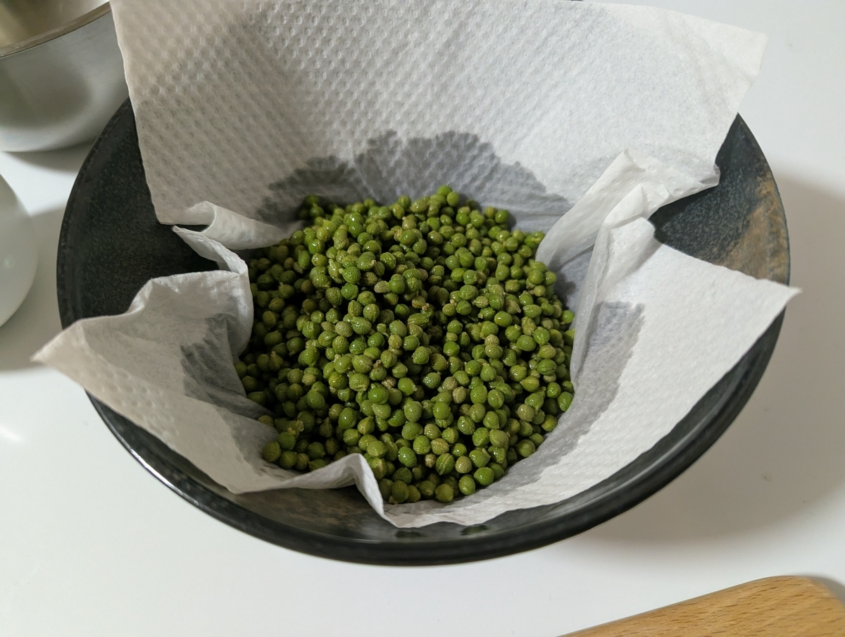 下茹で後の実山椒をキッチンペーパーの上で乾かしている工程。塩漬け前の水分除去
