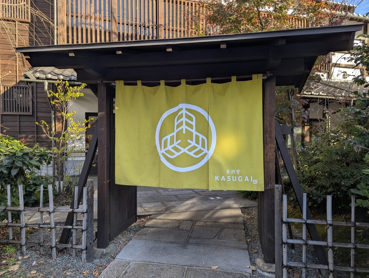 国立のクラフトビール居酒屋「麦酒堂KASUGAI」の外観。和風の門構えに黄緑色の暖簾が掛かり、100年以上続く酒屋が手がけるビアレストランらしい落ち着いた雰囲気。