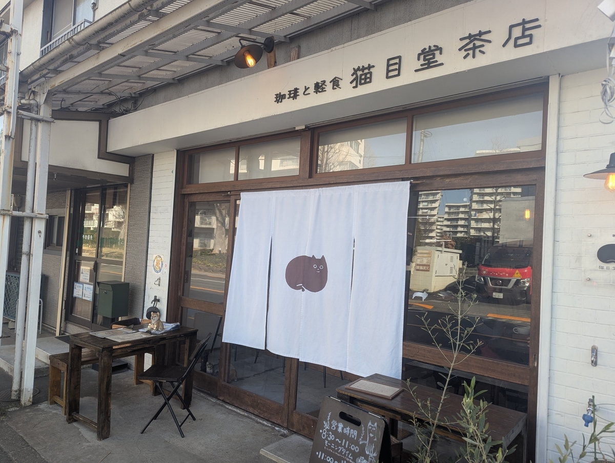東京都日野市・豊田駅近くにある喫茶店「猫目堂茶店」の外観。猫の暖簾がかかる落ち着いた店構え