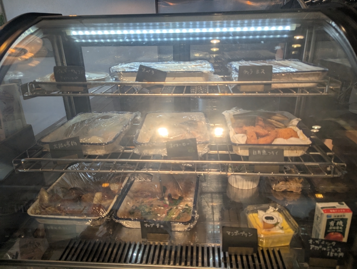 猫目堂茶店のショーケースに並ぶ日替わりのお惣菜とスイーツ。少しずつ選べるOYATSUスタイルのメニュー