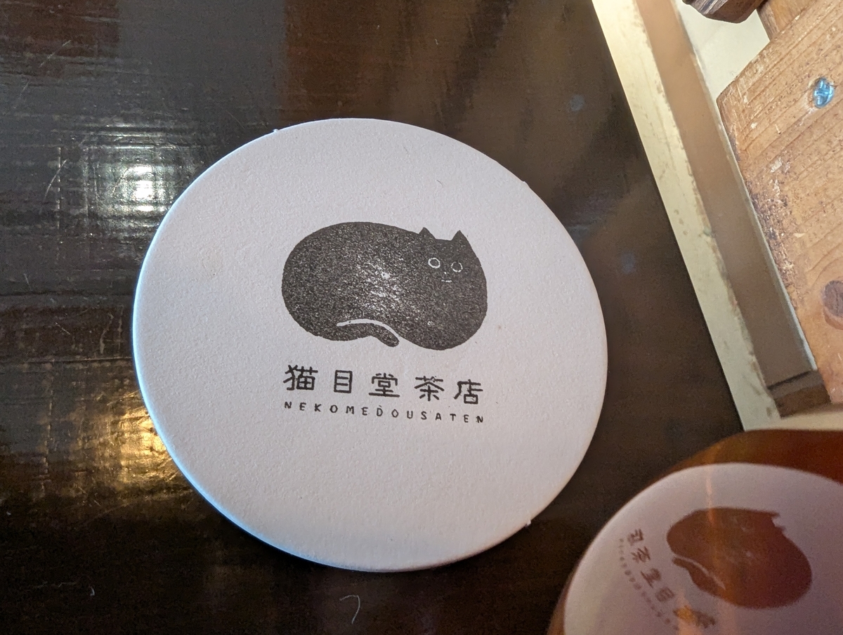 猫目堂茶店のロゴが描かれたドリンク用コースター