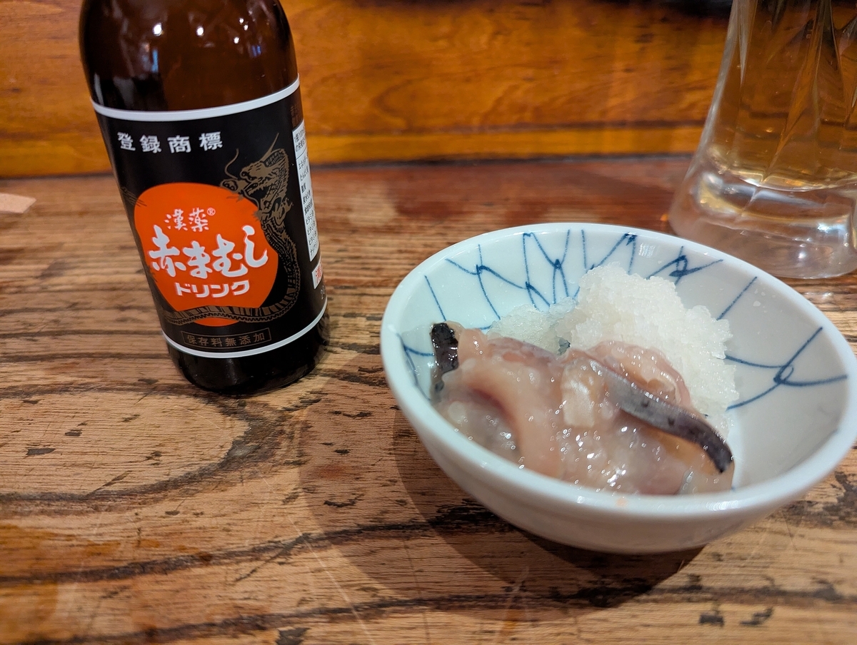 馬並み家 新橋のお通し｜赤まむしドリンクと塩辛の小鉢（ユニークな提供スタイルが印象的な一皿）