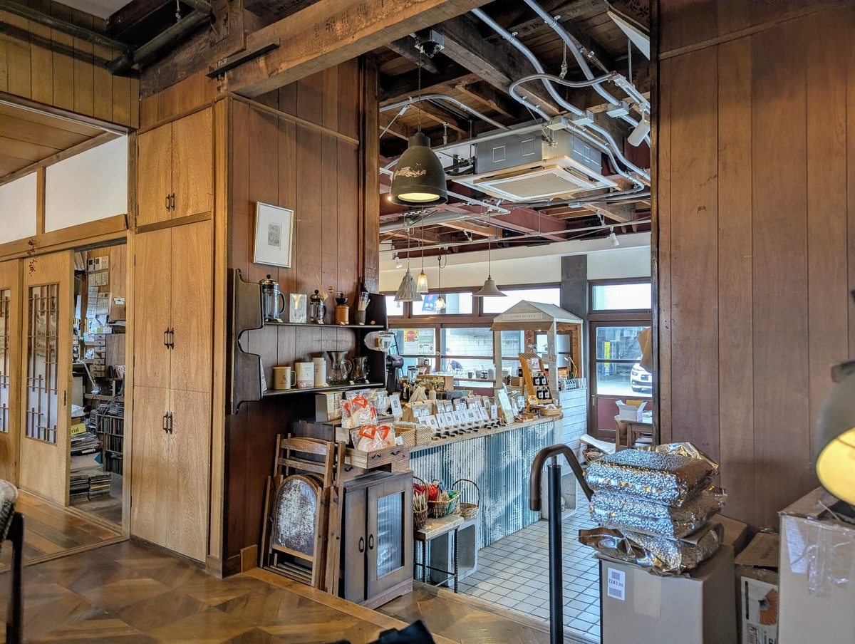 COFFEA EXLIBRIS kettleの店内。古民家の梁や木壁を活かした空間の奥にカフェスペースが広がる