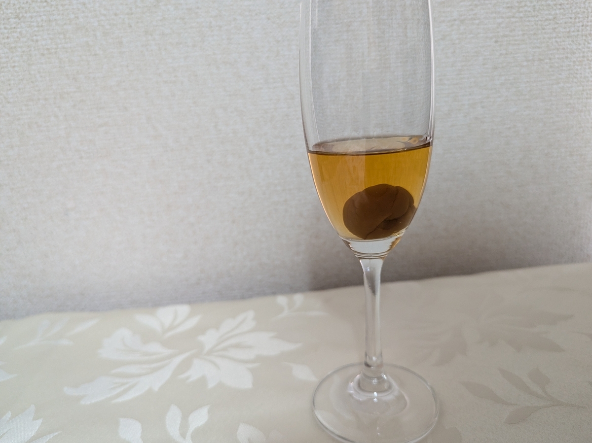 The CHOYA 至極の梅をシャンパングラスに注いだ様子。グラスの底に紀州産南高梅の実が沈んでいる