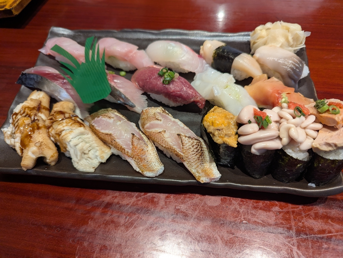 栄寿し総本店の握り盛り合わせ。穴子、のどぐろ炙り、中トロ、白子軍艦、あん肝軍艦など十数貫が一皿に並ぶ