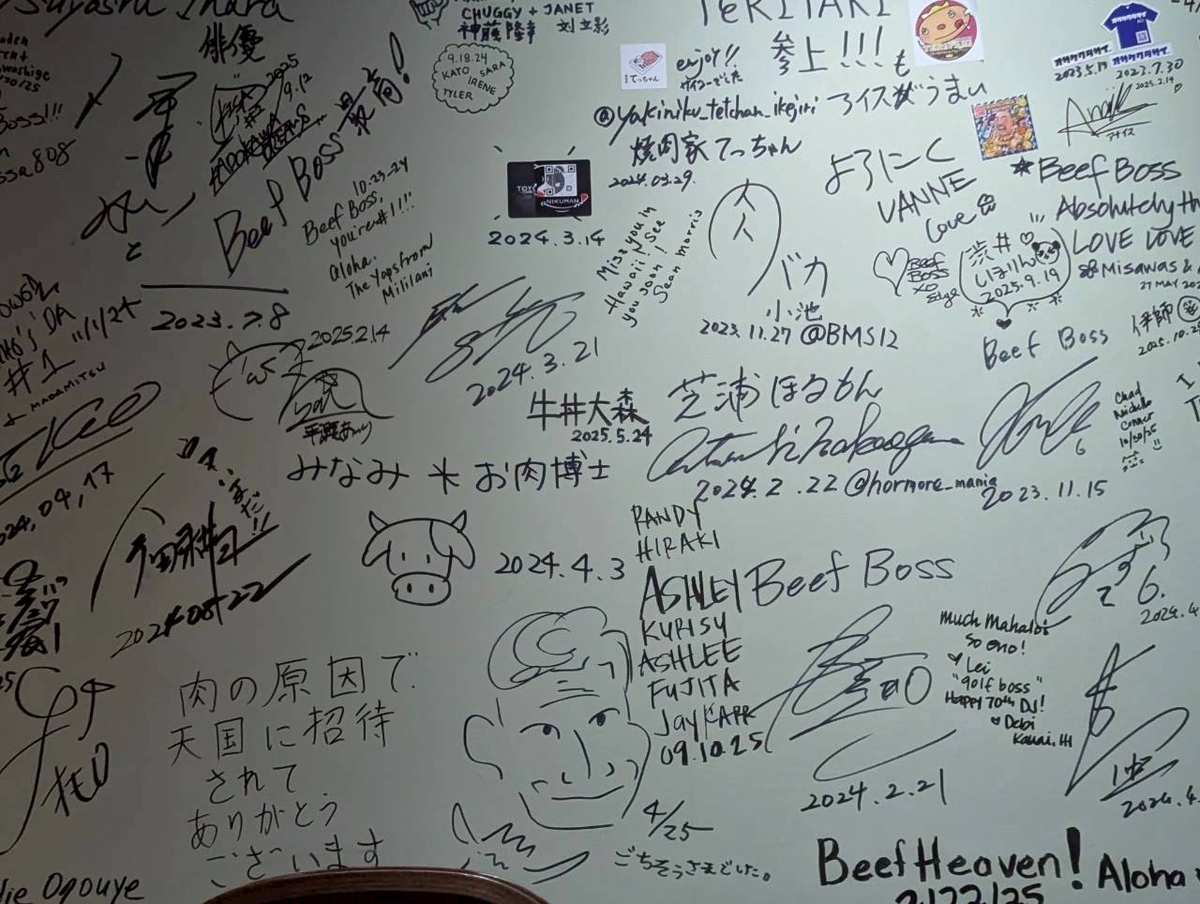 Beef Boss店内の壁一面に書かれたお客さんのサイン。日本語や英語のメッセージ、日付、牛のイラストなどがびっしりと並ぶ