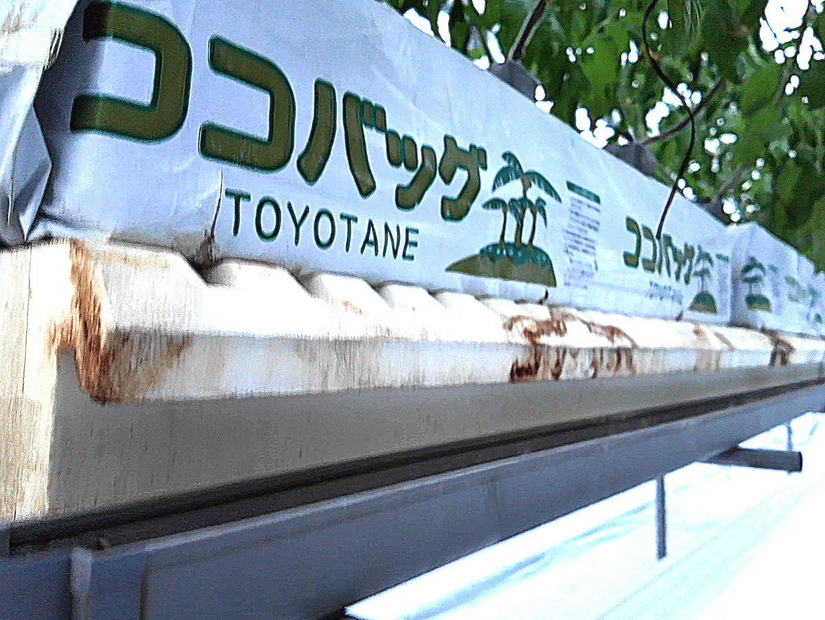澤藤園で使用されているヤシガラ培地「ココバッグ」(TOYOTANE製)。白いビニール包装に緑文字でロゴが印字され、トマトの根元に設置されている
