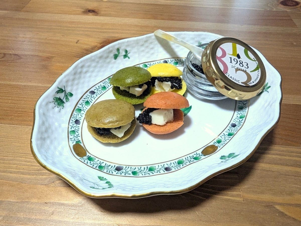 宮崎キャビア1983ブリニセットの完成形。4色ブリニにキャビアとバターを挟み、1983 J.CAVIARロゴ入り瓶と一緒にプレートに盛り付けた様子