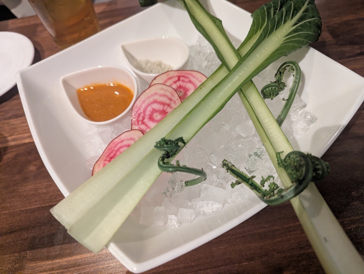 白い皿に氷を敷き、コゴミ・チンゲン菜・ビーツのスライスと味噌ディップが盛られた前菜
