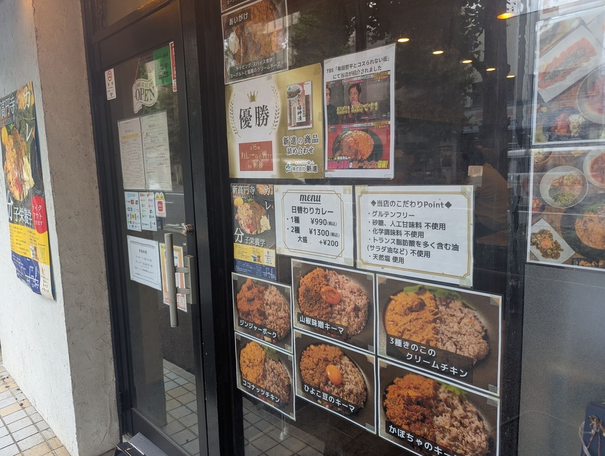 カレーライフバランス店頭。第15回カレーなる戦いin杉並 優勝マーク、TBS有田哲平とコスられない街放映ポスター、こだわりPoint表記、日替わりカレー6種の写真