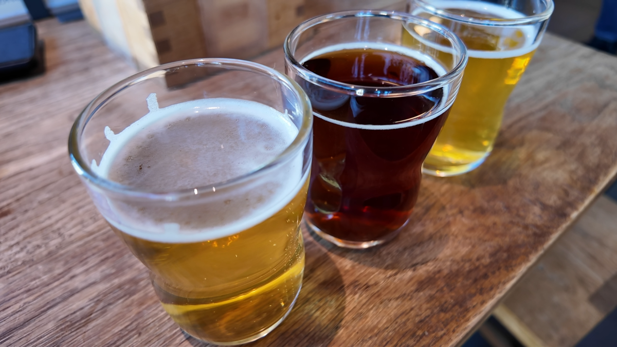 木の升トレイに並んだ、色の異なる3種類のクラフトビールの飲み比べセット