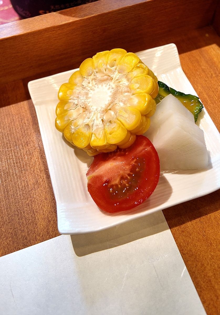 とうもろこし、トマト、うり、ゴーヤが盛られた夏野菜の小皿
