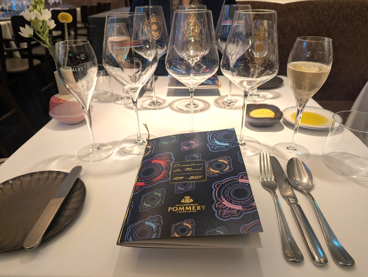 Créateur du Brut 1874-2024と記された紺のポメリーのブックレットが置かれたテーブル