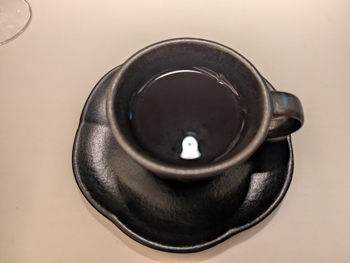 黒い釉薬のカップアンドソーサーに注がれた珈琲