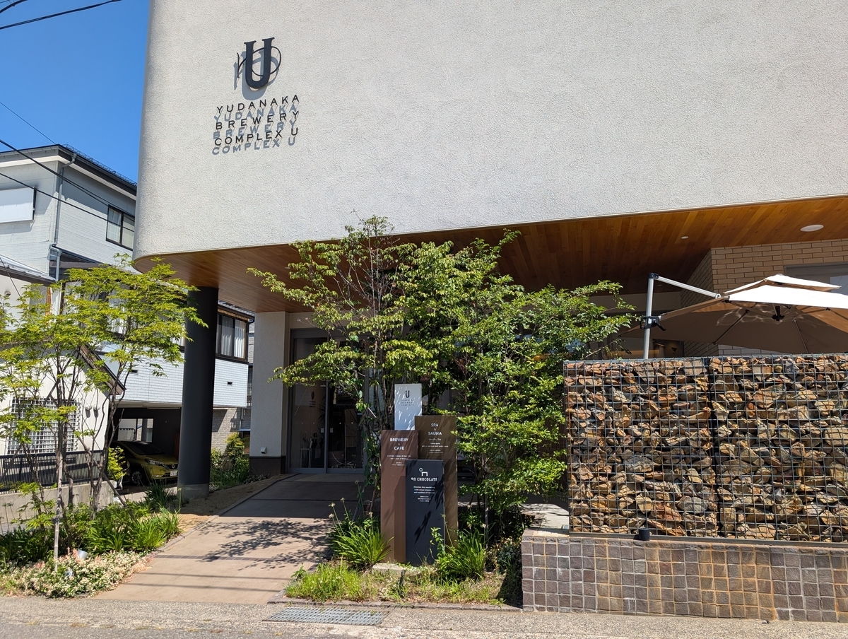YUDANAKA BREWERY COMPLEX U の外観。石を詰めたガビオン壁とUのロゴ