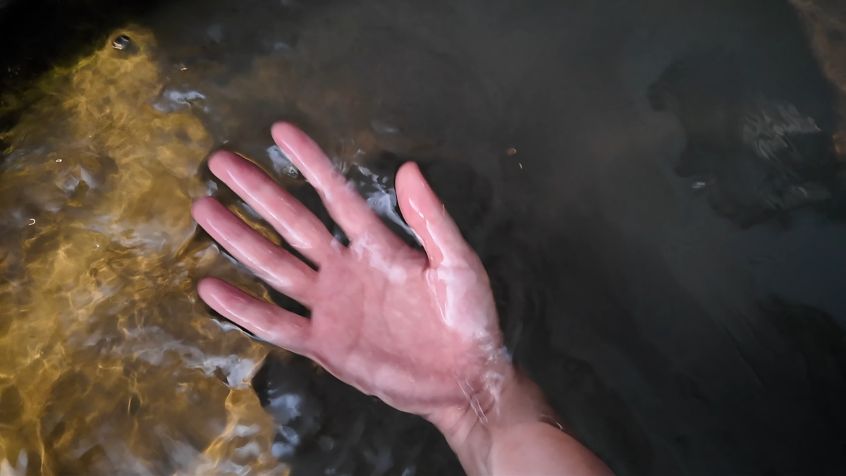 ビールを混ぜた水風呂の水を手ですくっているところ