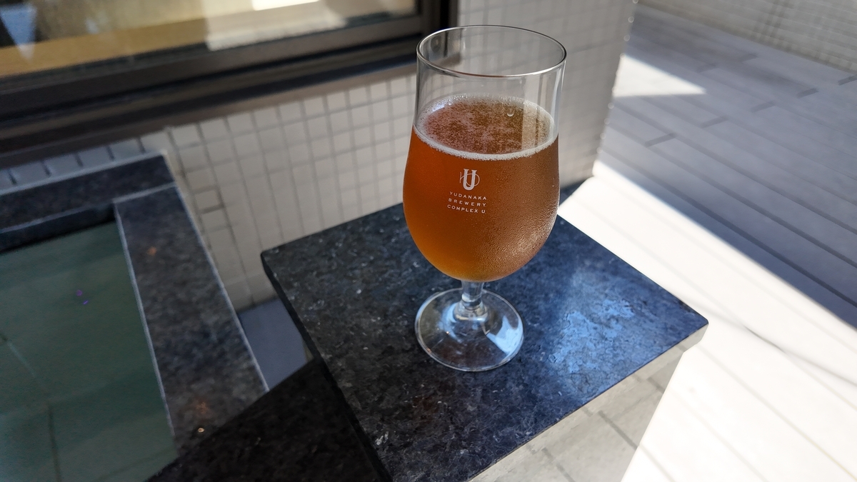 Uのロゴが入ったグラスに注がれたビール