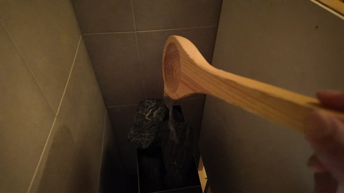 柄杓でサウナストーンに水をかけようとしているところ