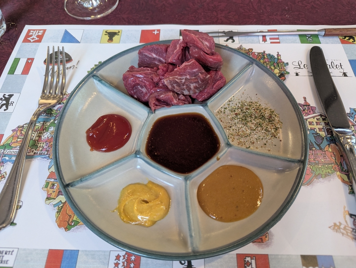 ル・シャレーのオイルフォンデュ用の仕切り皿。一口大の牛ヒレ肉と、マスタード・ケチャップ・カレーソース・ハーブ塩など5種の薬味