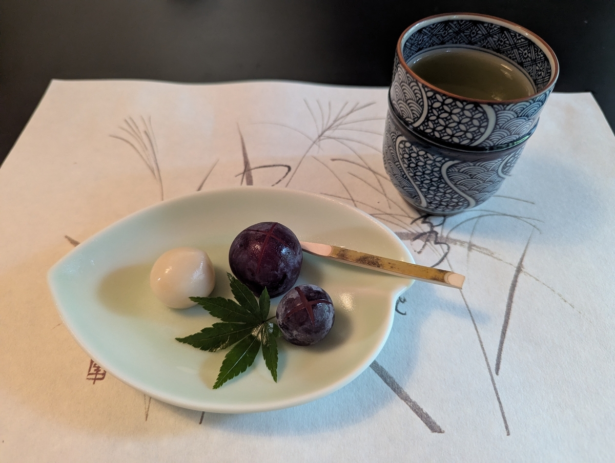 澤乃井ままごと屋の甘味。絹ごし豆腐のあんこ玉とぶどう、紅葉の葉と黒文字が添えられている