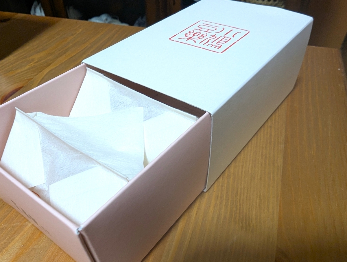 小鳩豆楽の折箱 白い薄紙の折り包みが3包並んでいる