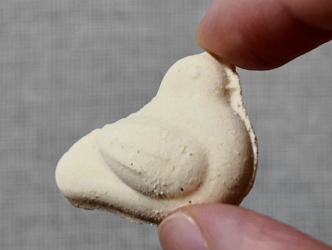 小鳩豆楽 指でつまんだ小鳩の干菓子のアップ 羽と目の型が出ている