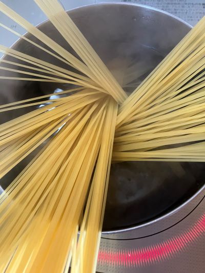 沸騰した水にパスタを広げている様子