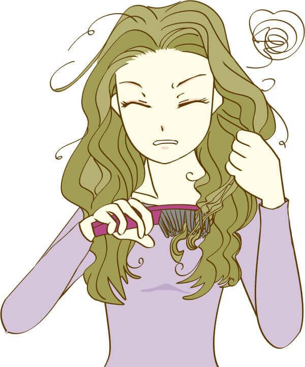 ボサボサの髪にブラシをあてている女性