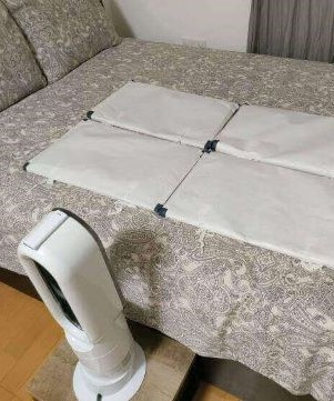 ベッドの上にたとう紙を置きダイソンで風を当てている状態