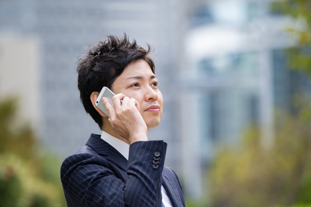 スマホで電話しているフレッシュなビジネスマン