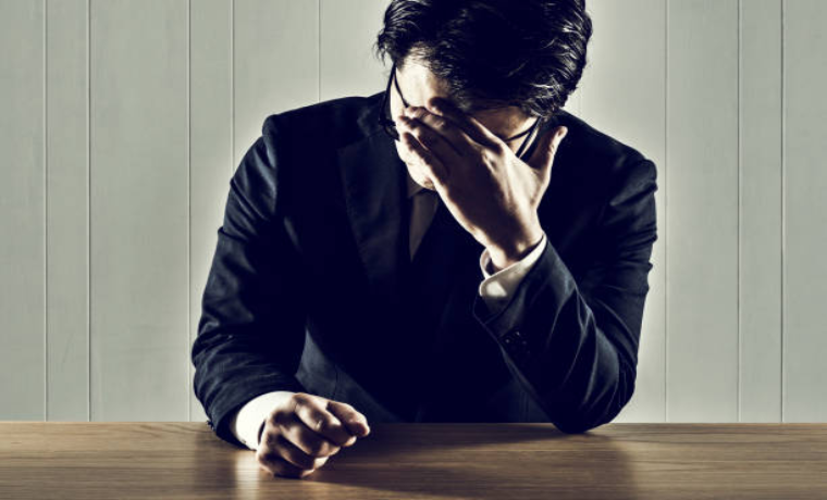 辛そうに悩んでいるスーツ姿の男性社員