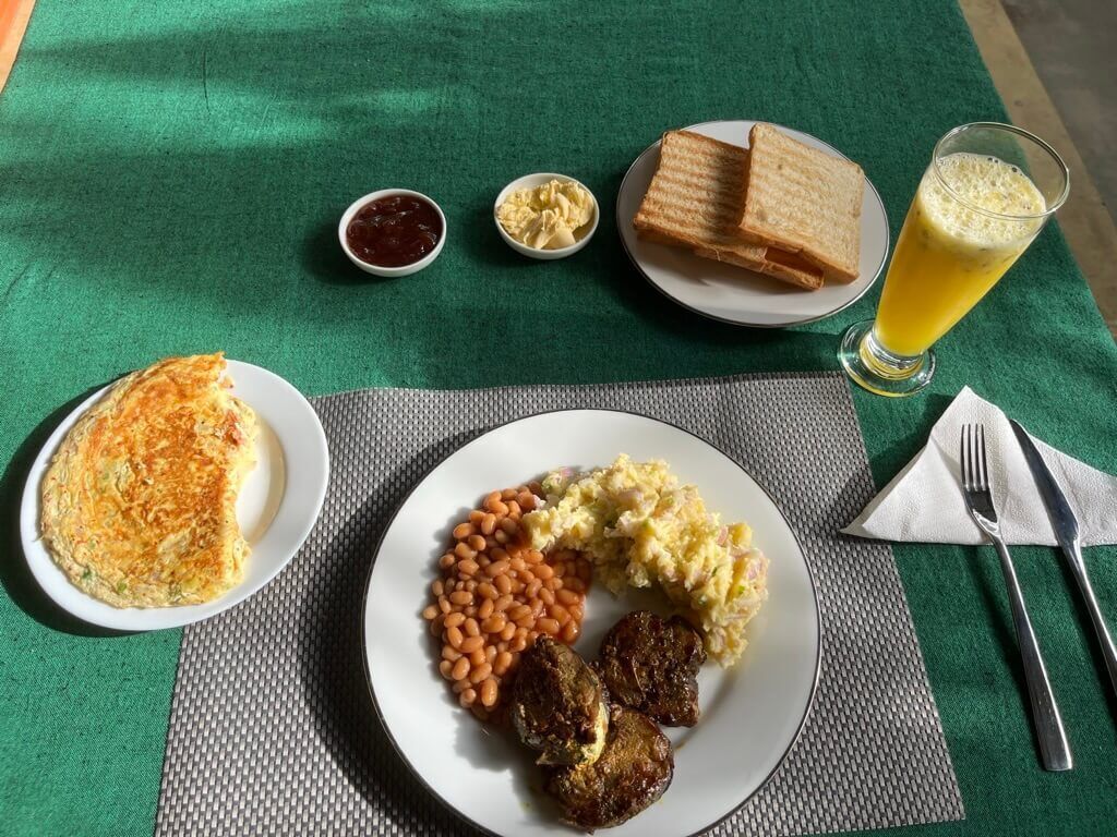 食べ過ぎた翌日の朝ご飯 パッションフルーツジュース チーズ入りオムレット パラウマール Paraw Fish の生姜ソテー ポテサラ 豆のトマト煮 パン