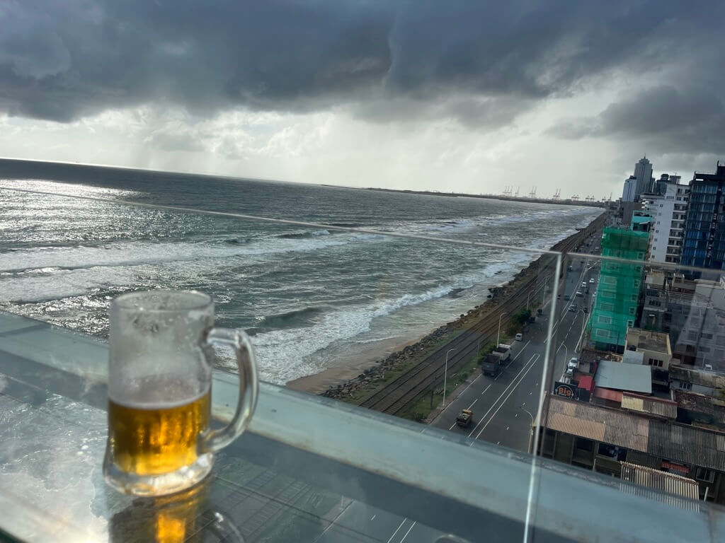 海と車を見ながら飲むライオンラガー ルーフトップバー オーシャンビュー Sky Yard Bar &amp; Lounge Hotel MaRaDha Colombo（ホテルマラダコロンボ