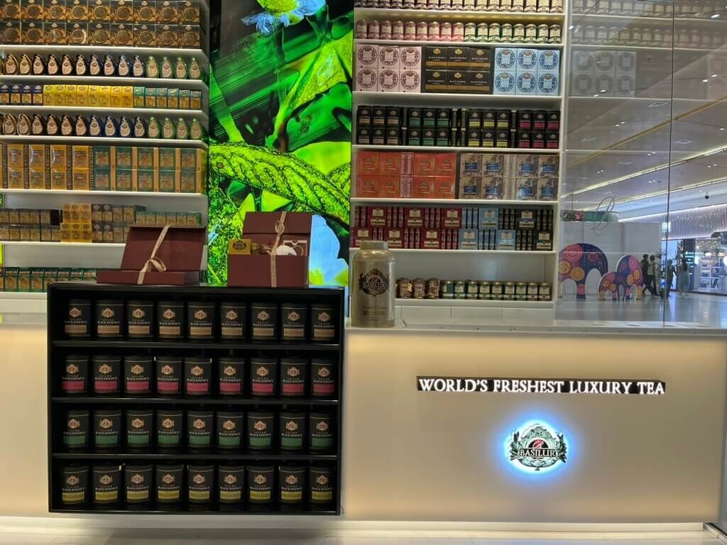 Port CityのBasilur Tea Gallery &amp; Boutique店内カウンター。背面に茶葉棚とデジタルパネル。