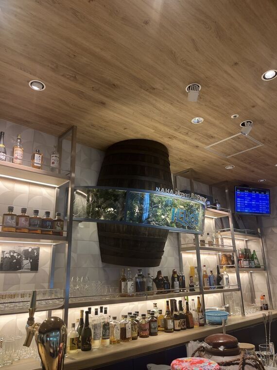 HELIOS那覇空港ブルワリーの店内（カウンター・樽・ボトル棚）