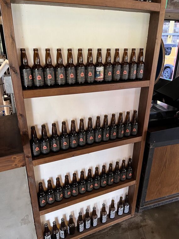 Frankey Tavernの瓶ビール陳列棚にRise &amp; Winのボトルが並ぶ