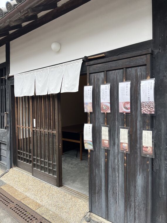 茶寮百代の外観 白暖簾とメニューが並ぶ古民家の入口