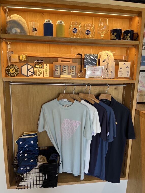京都醸造オリジナルグッズの棚、Tシャツやグラスなど