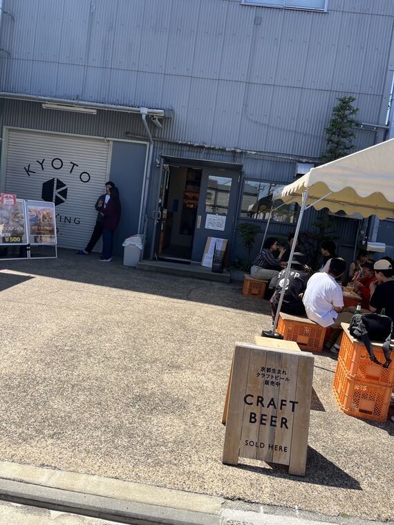 京都醸造タップルーム外観、CRAFT BEER看板とテラス席で飲む客