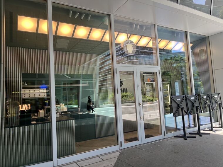 うちゅうブルーイング虎ノ門タップルームのガラス張り入口 店内のカウンターと缶ボトル棚が透けて見える