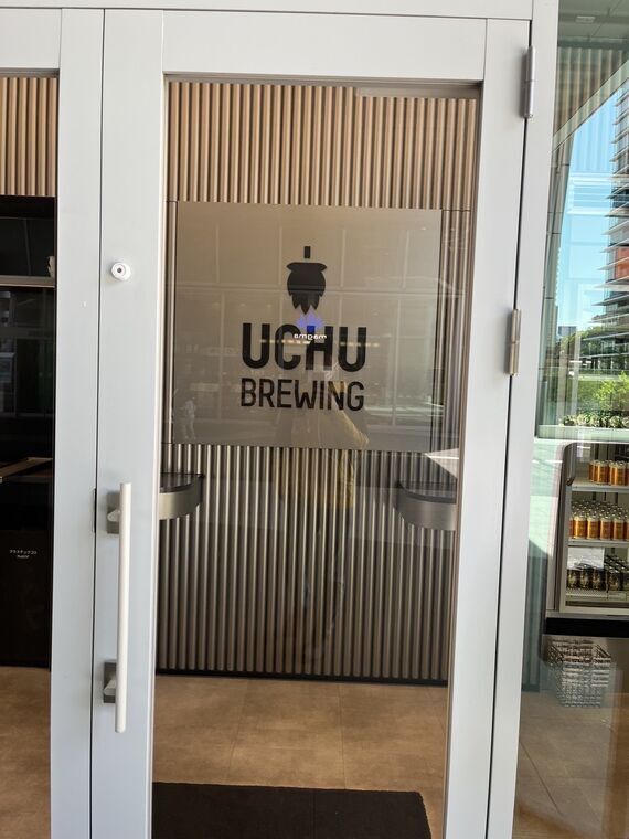 UCHU BREWING ロゴが入ったタップルームのガラスドア 宇宙人風マスコットキャラクター