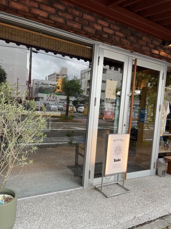 Yadoのガラス張りの外観と立て看板