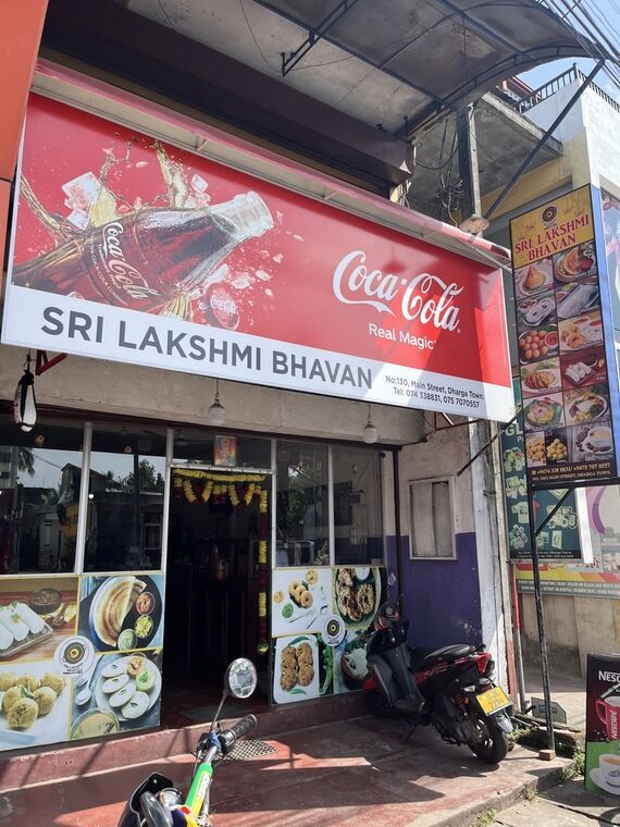 Sri Lakshmi Bhavanの外観。コカ・コーラの看板と料理写真が並ぶ入口