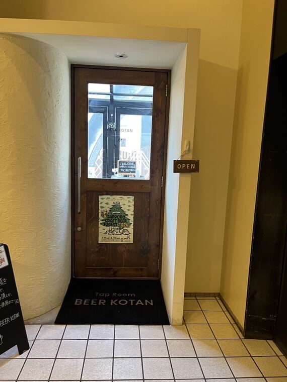 Tap Room BEER KOTANの入口窓とOPENサインとSAPPORO CRAFT BEER FOREST 2026ポスター
