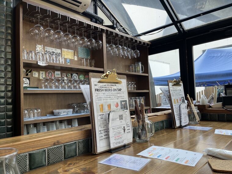 Tap Room BEER KOTAN札幌大通の店内カウンターとグラス棚と天井ガラス